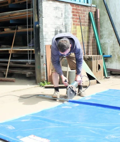 man cutting tarpaulin